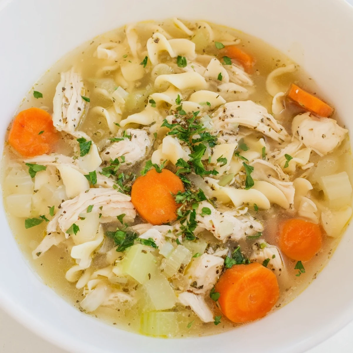 Flavorful homemade Chicken Noodle Soup garnished with fresh parsley, perfect for a cozy dinner.
