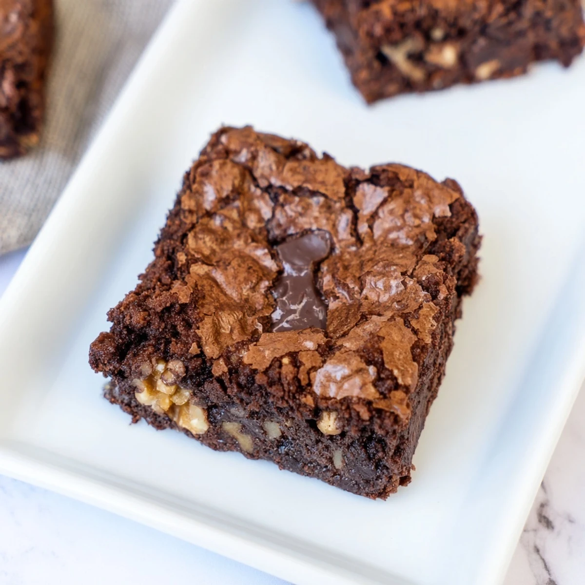 Warm chocolate brownie, a rich, fudgy square with a crackly top, ready to serve.