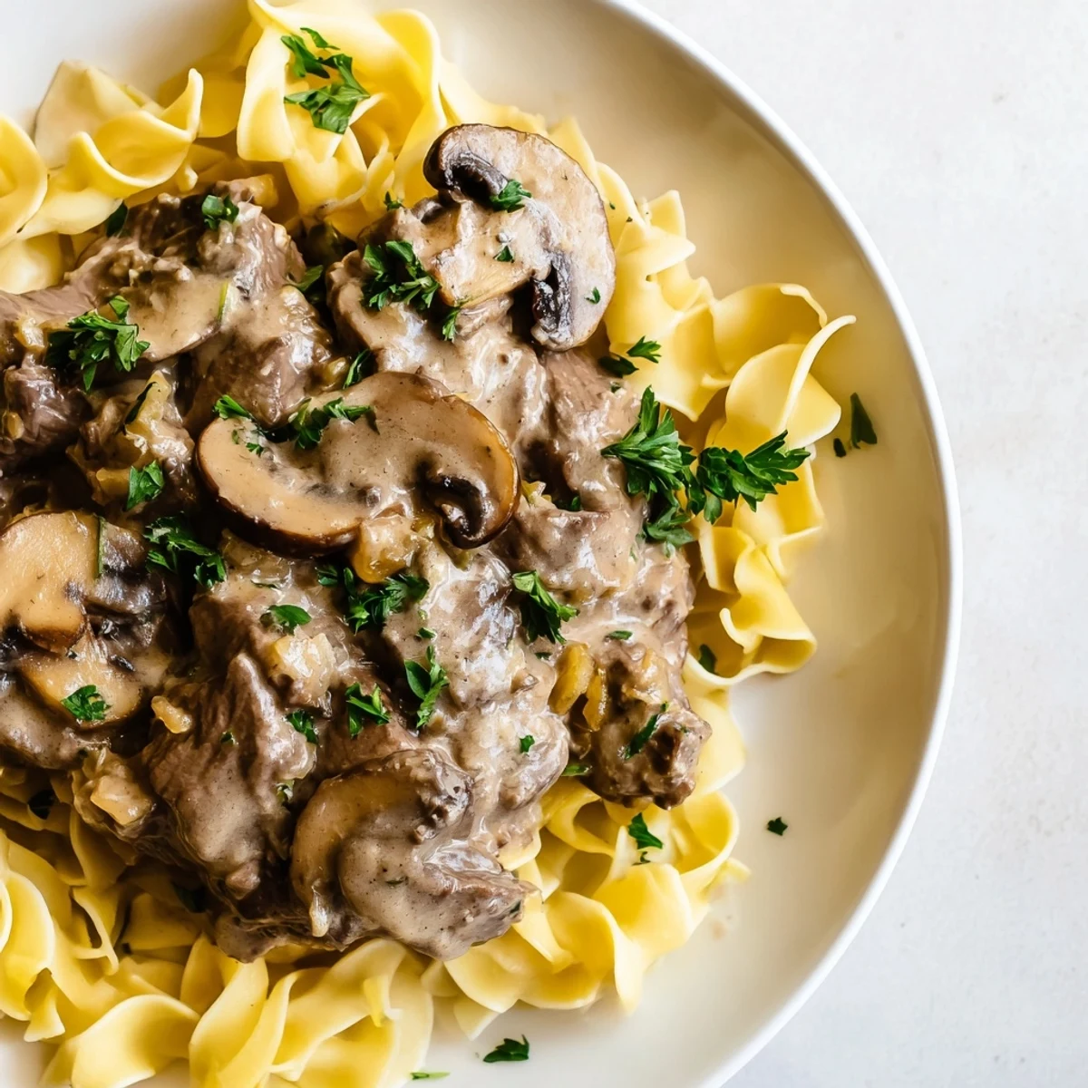 Savory Rich Beef Stroganoff with creamy mushroom gravy, served atop buttery egg noodles.