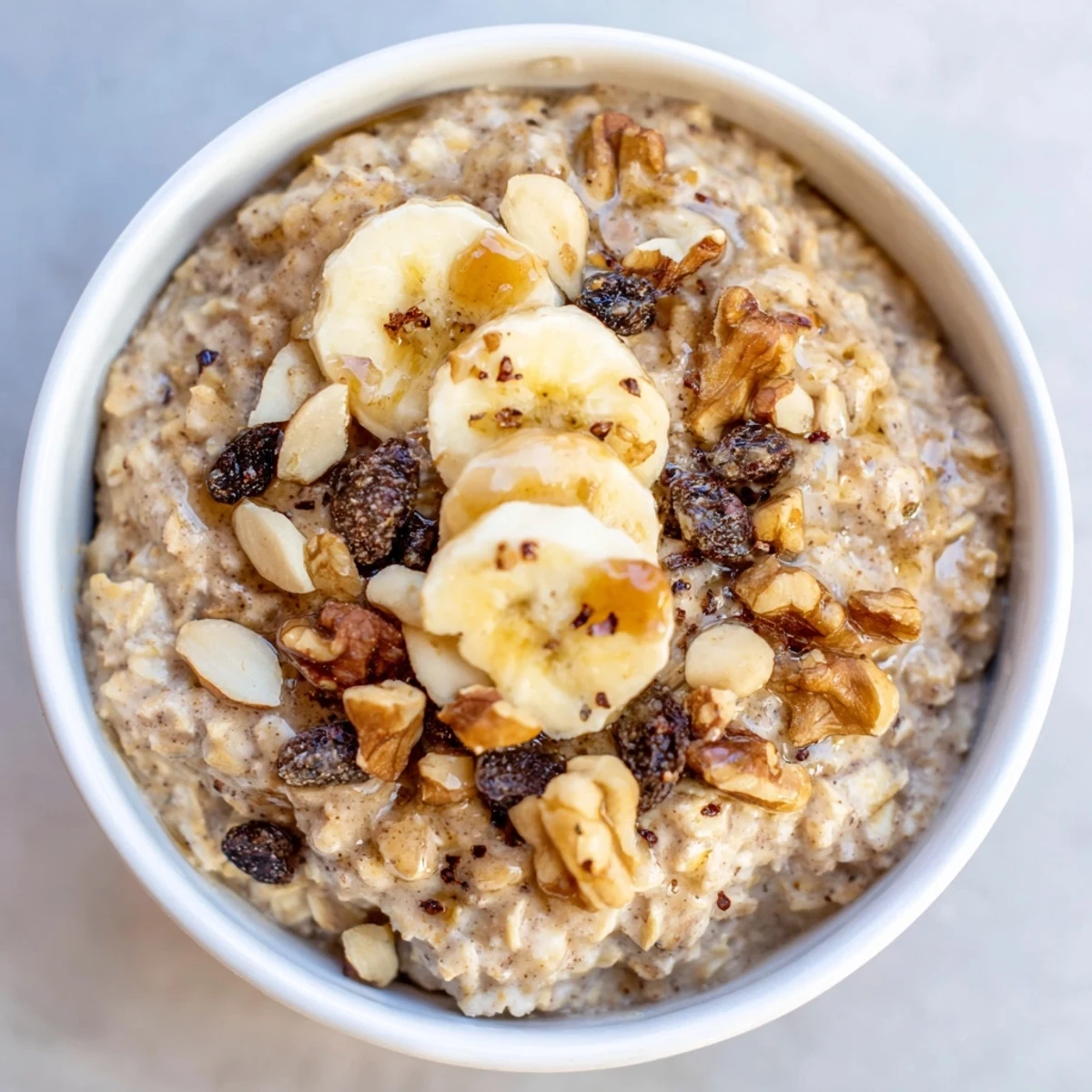 Steaming bowl of warm chai spice oatmeal, topped with nuts and fruit for a hearty breakfast.