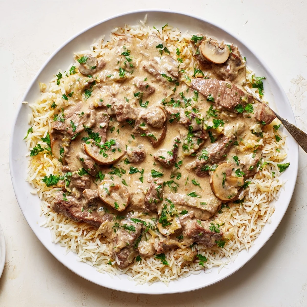 Tender beef stroganoff with rice, featuring creamy mushrooms and a flavorful, hearty sauce.