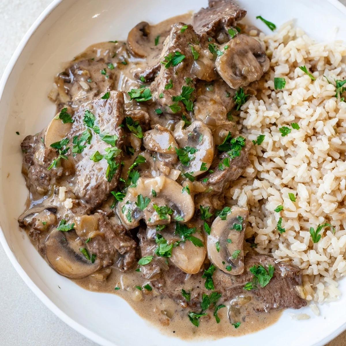 A comforting close-up: Homemade beef stroganoff, served over fluffy white rice, is a delicious dinner!
