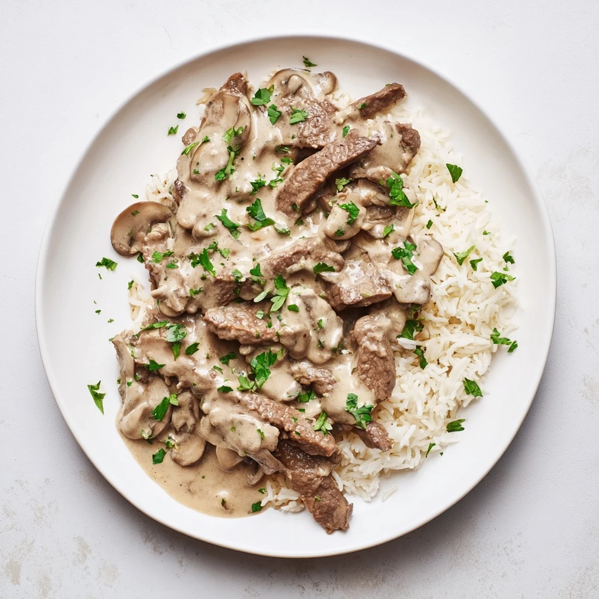 Rich beef stroganoff, a classic, savory meal, glistening in a creamy sauce over light rice.