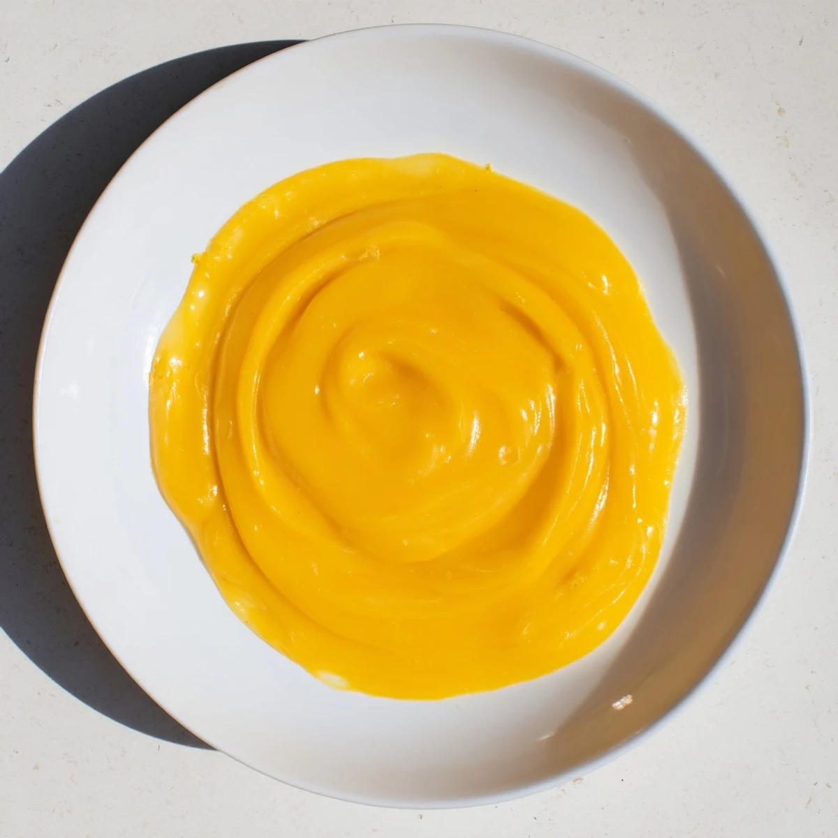 Creamy homemade zesty lemon curd in a glass jar, perfect for spreading on toast with friends.