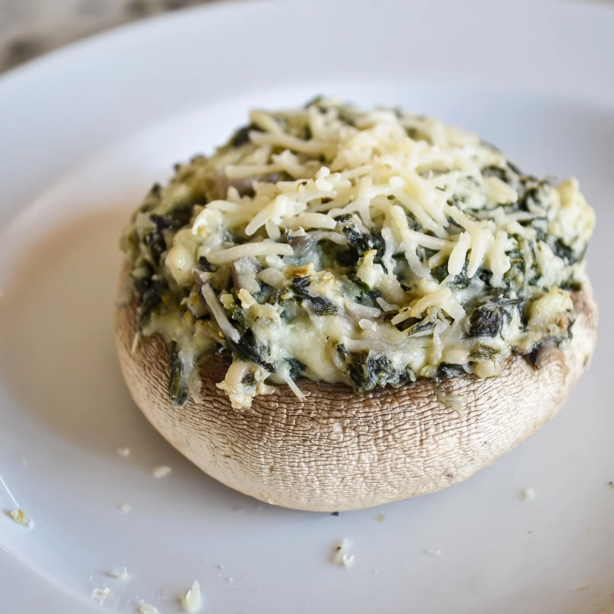 Appetizing close-up of Cheesy Spinach Artichoke Stuffed Mushrooms, with bubbly cheese and savory aroma.
