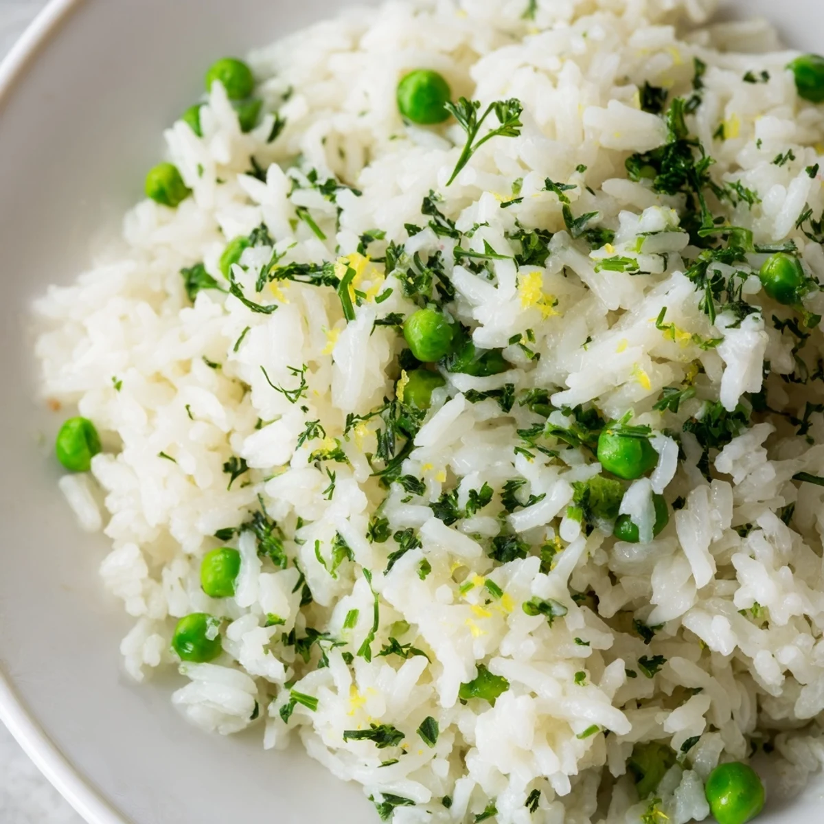 Steaming Lemon Herb Rice Pilaf in a skillet, featuring tender grains, lemon zest, and vibrant green peas.