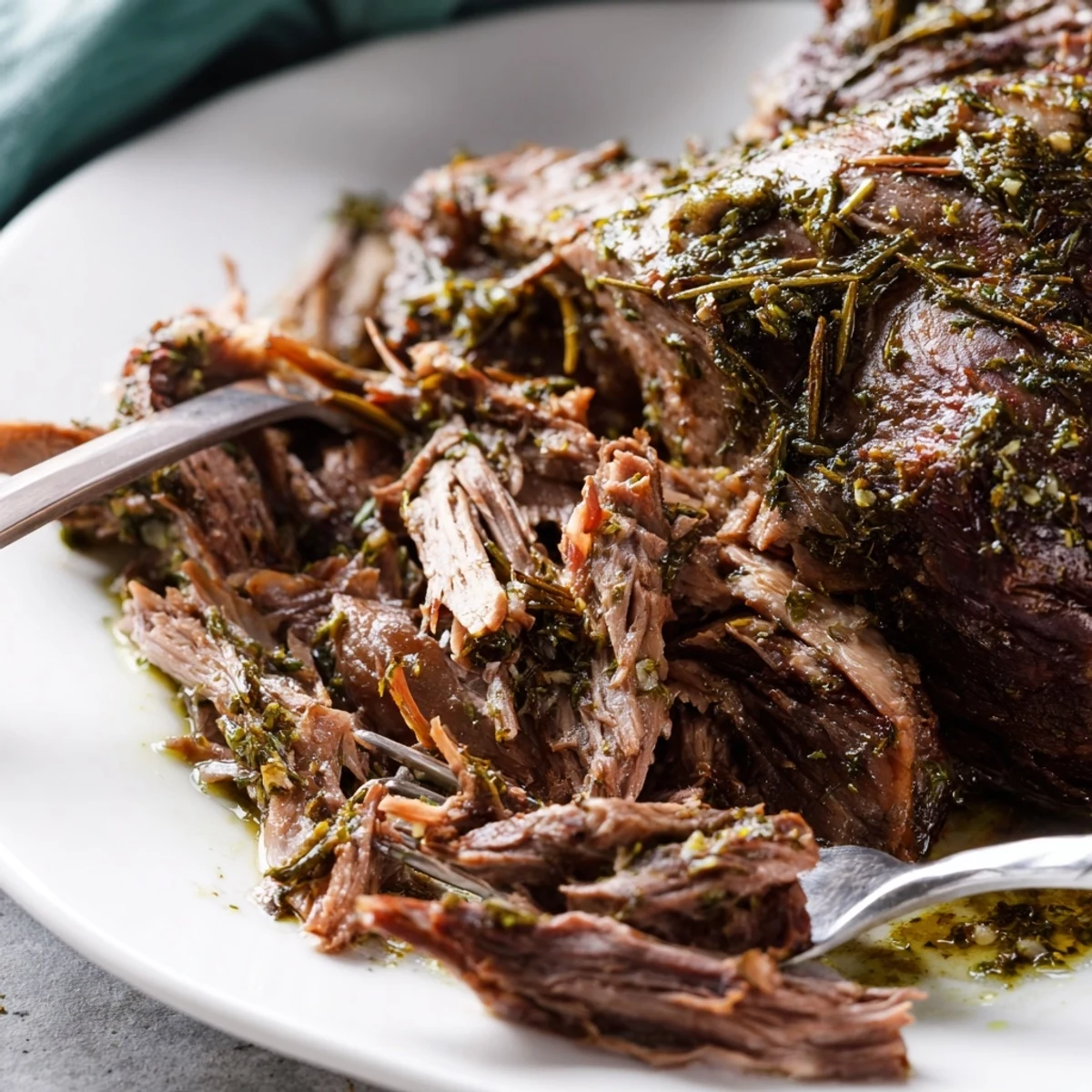 Tender slow cooked lamb shoulder with garlic herbs, served with roasted carrots and onions in a rich pan sauce.