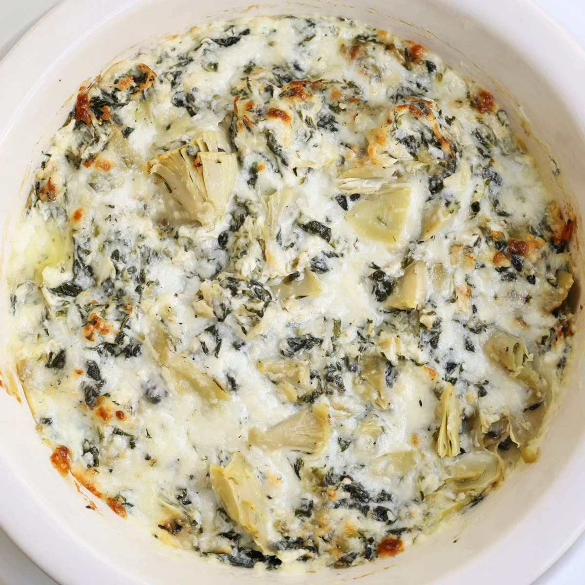 Golden-brown, bubbly Super Bowl Spinach and Artichoke Dip fresh from the oven, served with crispy toasted pita wedges for dipping.