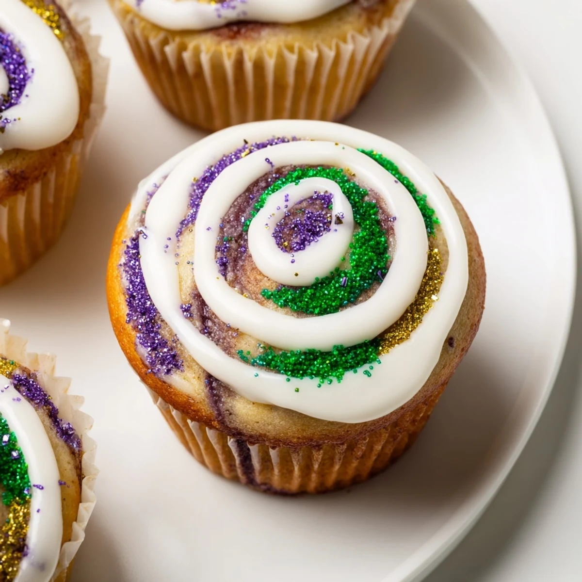 Festive Mardi Gras King Cake Cupcakes are frosted with colorful sugar, offering a taste of New Orleans' celebration.