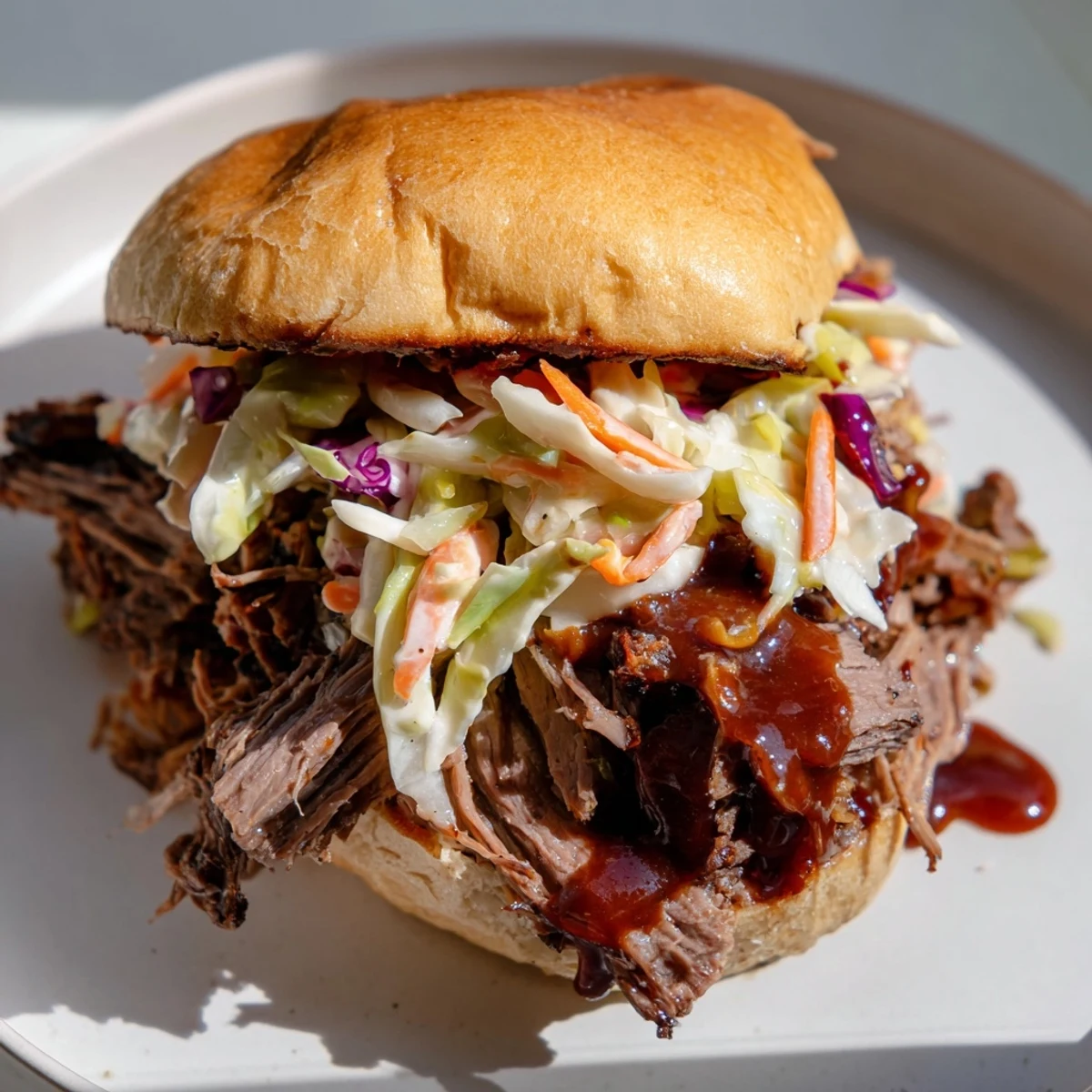 Tangy homemade coleslaw and saucy MVP Pulled Beef Sandwiches stacked high on a plate, perfect for a casual game day meal.