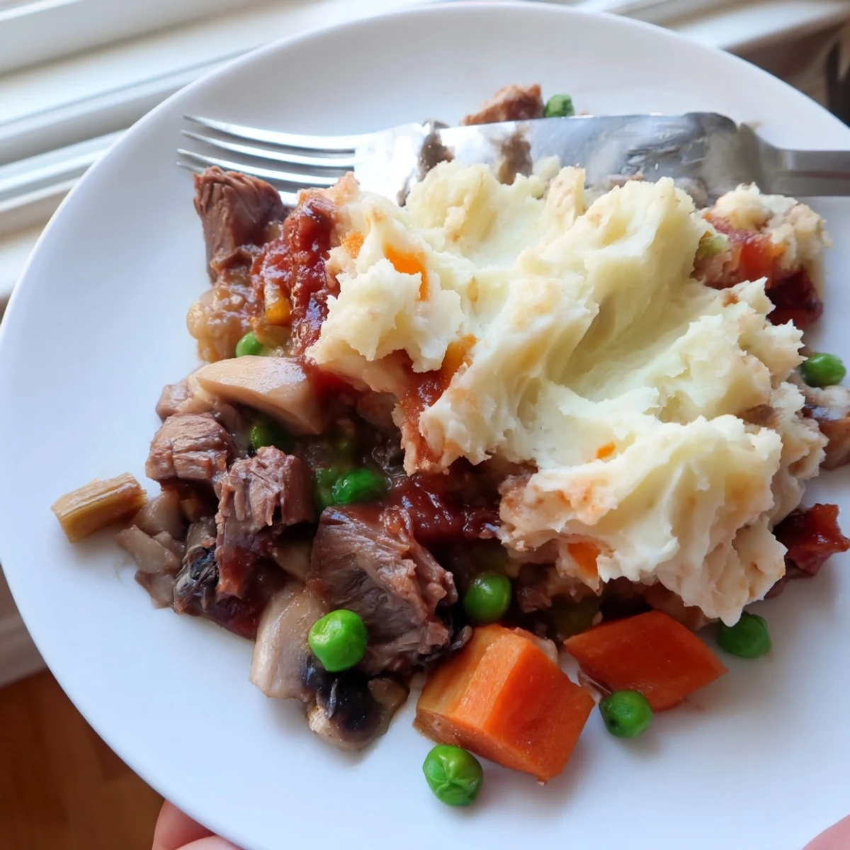 Golden-brown Shepherd’s Pie with Braised Lamb, crowned with creamy mashed potatoes and bubbling at the edges.  