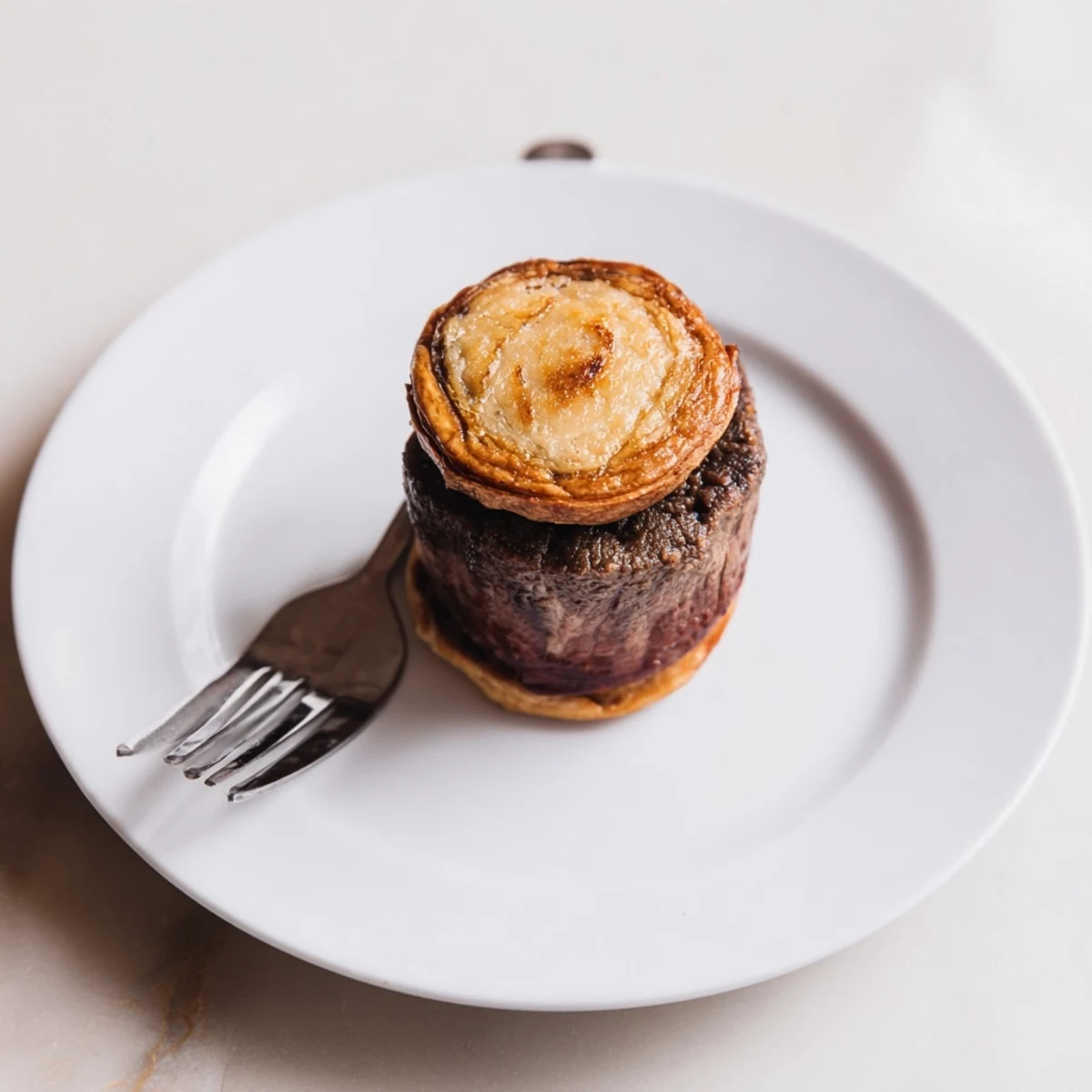 Savory Mini Beef Wellingtons topped with prosciutto and mushroom duxelles, baked to a golden brown and ready to serve on a platter.