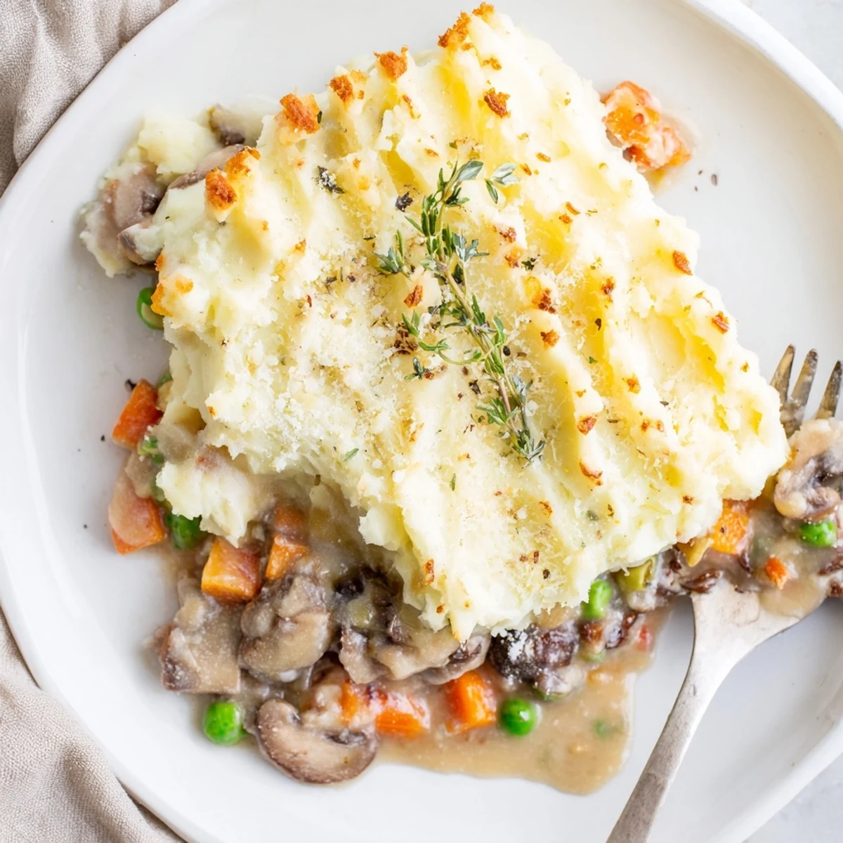 A close-up of vegetarian Creamy Mushroom and Leek Shepherds Pie, with a creamy filling and crispy potato topping.  