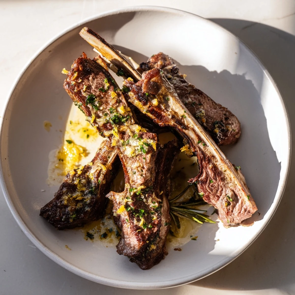 Tender Air Fryer Lamb Chops with Lemon Butter sit plated beside fresh asparagus and a glass of red wine.