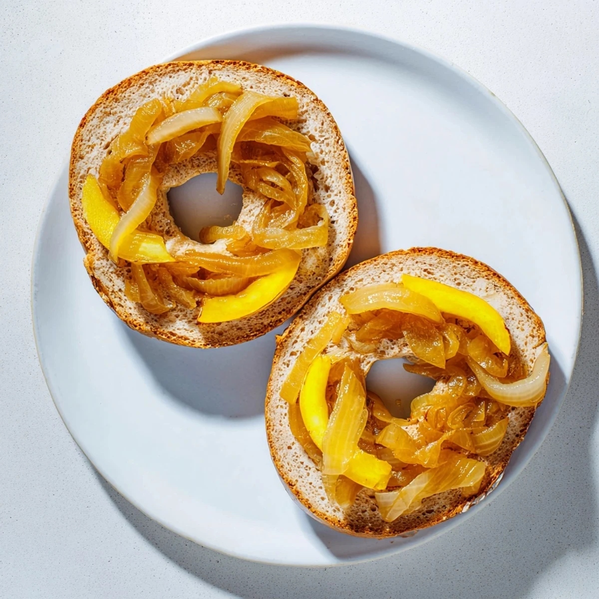 Homemade Sourdough Onion Bagels arranged on a cooling rack, showcasing a glossy crust and savory sweet onion topping.