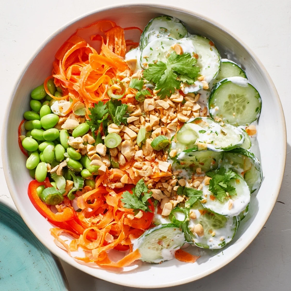 Freshly sliced cucumbers and crunchy vegetables sit in a creamy dressing in this vibrant Creamy Asian Cucumber Bowl.