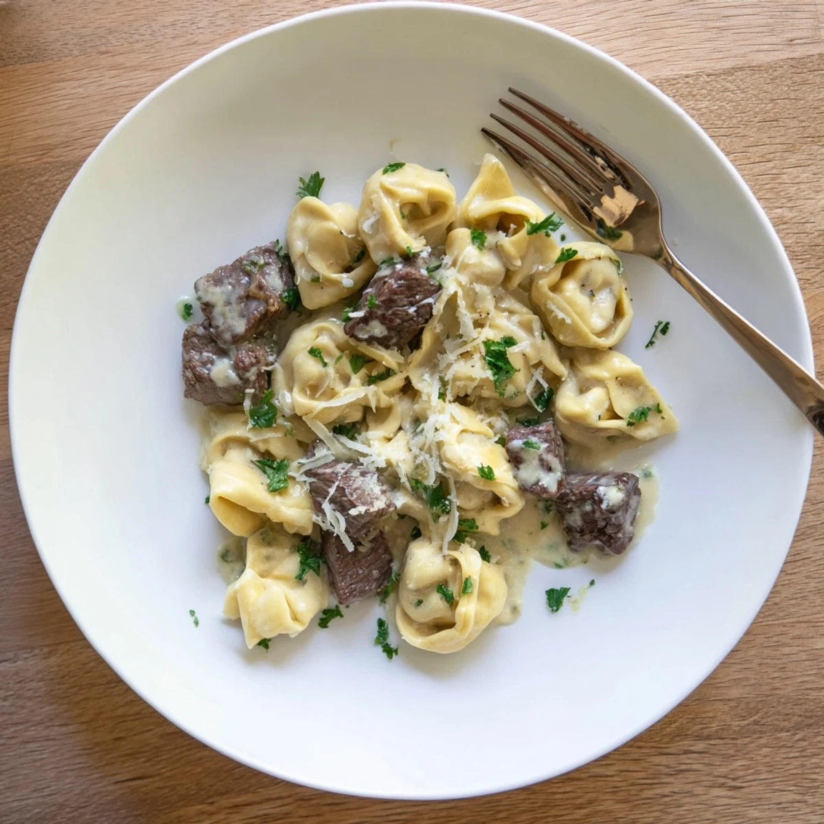 Freshly cooked cheese tortellini and tender steak bites smothered in a rich, garlicky cream sauce for a cozy dinner.