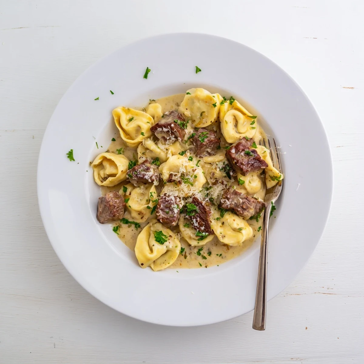 Sizzling steak cubes and pasta twirls coated in a velvety, garlicky sauce, creating an irresistible Italian-American main dish.