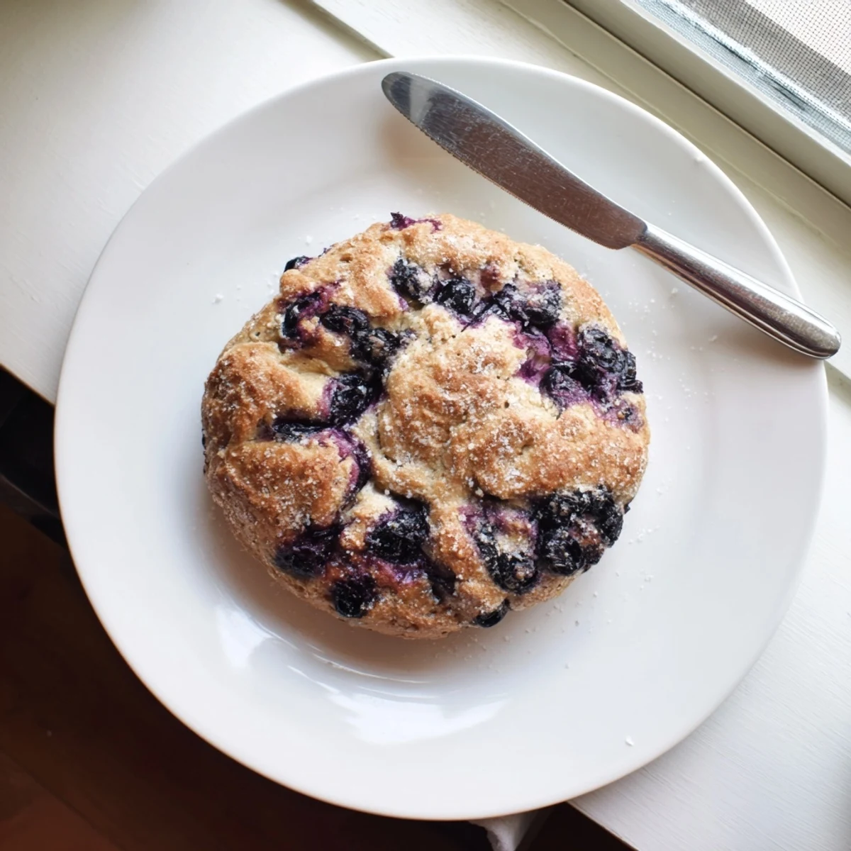Freshly baked Gluten-Free Blueberry Bagels on a wire rack, studded with juicy blueberries and lightly sparkling with coarse sugar.