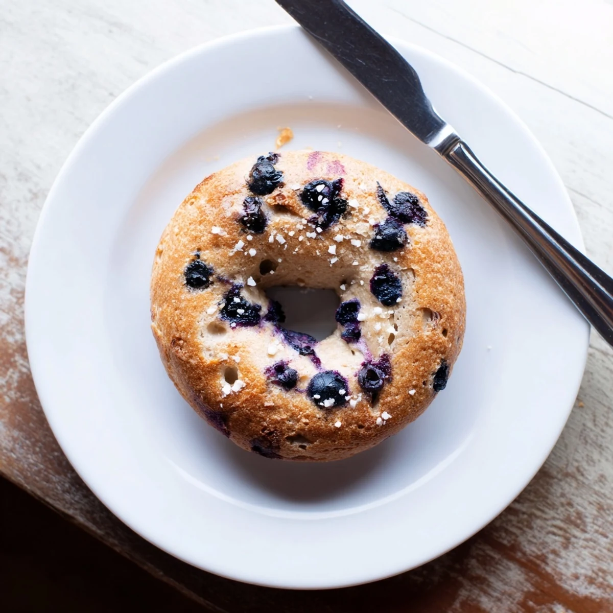 Golden-brown Gluten-Free Blueberry Bagels cooling on a rack, ready to be sliced and served with a thick schmear of cream cheese.