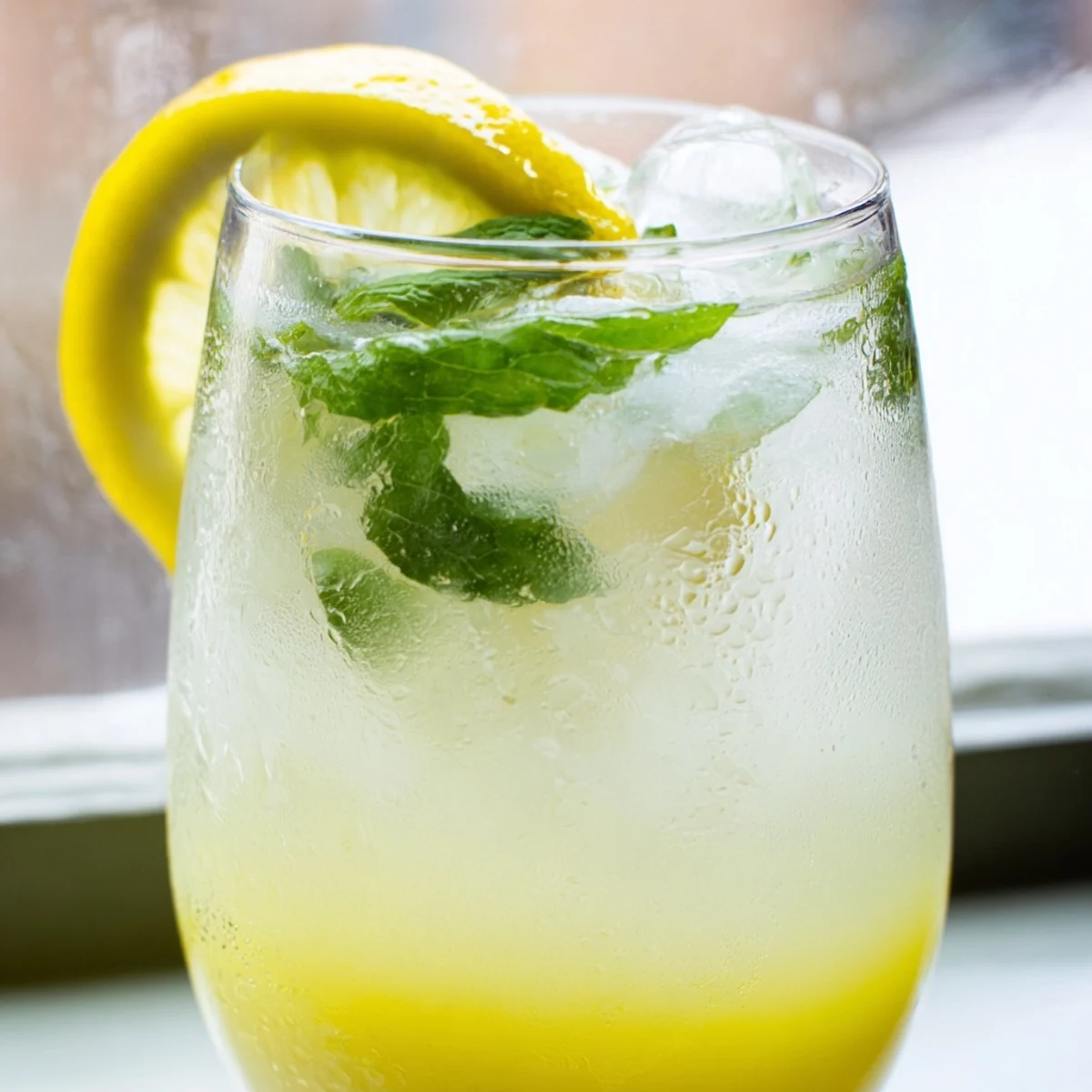 Bright and bubbly Easy Limoncello Mocktail Refreshing Drink with lemon slices and mint over ice.