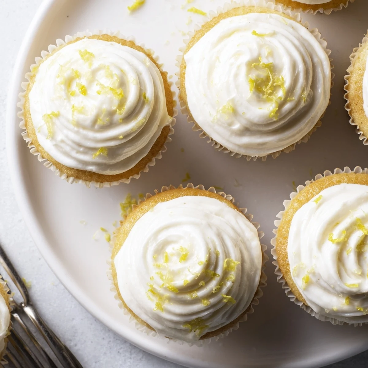 Moist Italian-inspired Limoncello cupcakes served on a decorative plate, perfect for summer gatherings.
