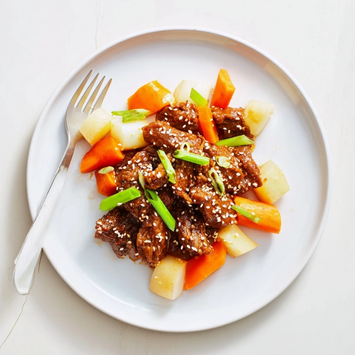 Tender, shredded Korean Style Pot Roast with carrots and daikon simmered in a glossy soy-ginger glaze, served with steamed rice.