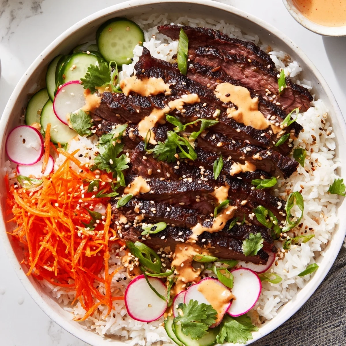 Fluffy rice and tender marinated steak with spicy cream sauce, served with fresh veggies in a colorful bowl.