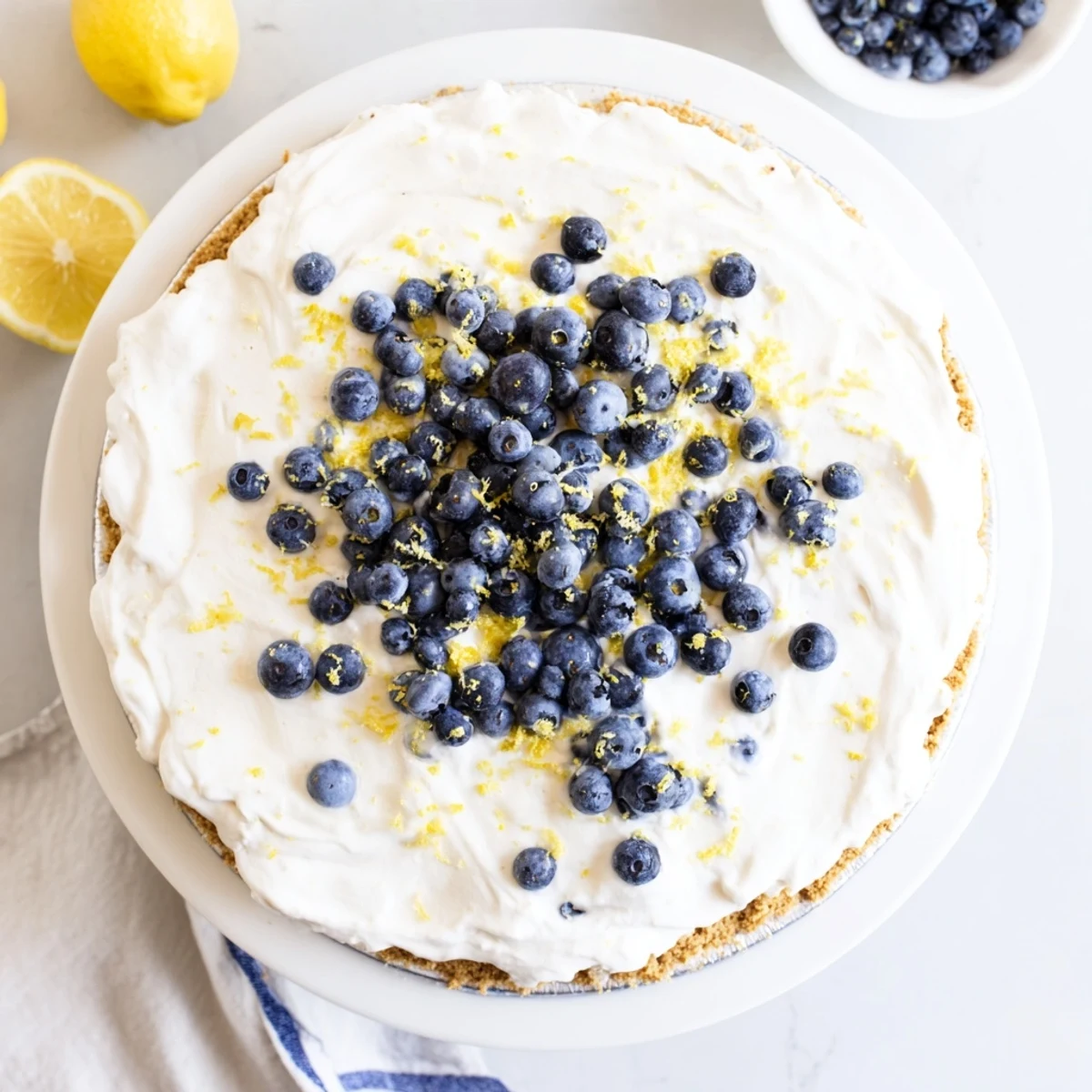 Vibrant slices of No Bake Lemon Blueberry Cream Cake showcase fresh berries and a creamy lemon filling on a chilled graham cracker crust.