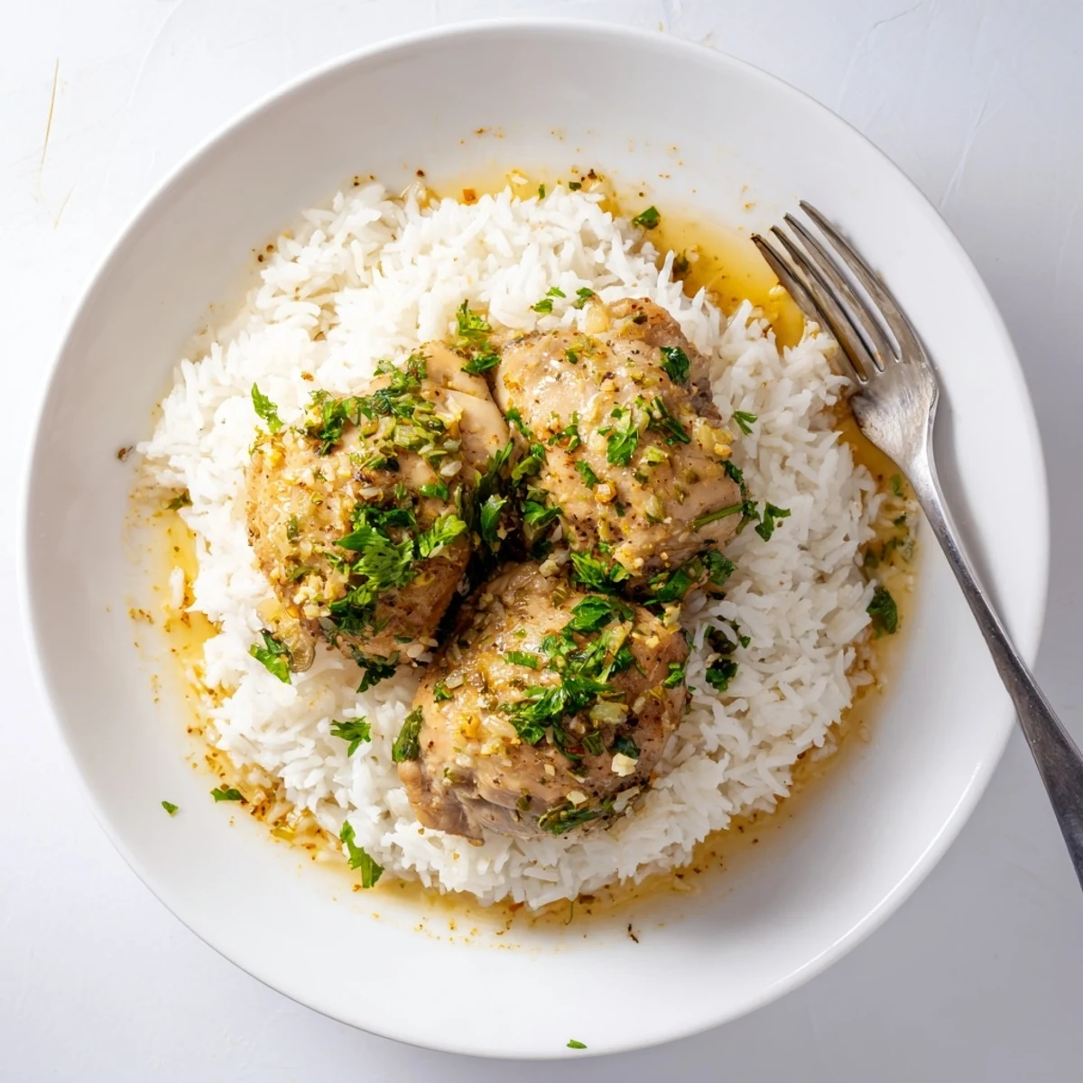 Bright lemon herb chicken thighs glistening over fluffy rice, garnished with fresh parsley in a slow cooker.