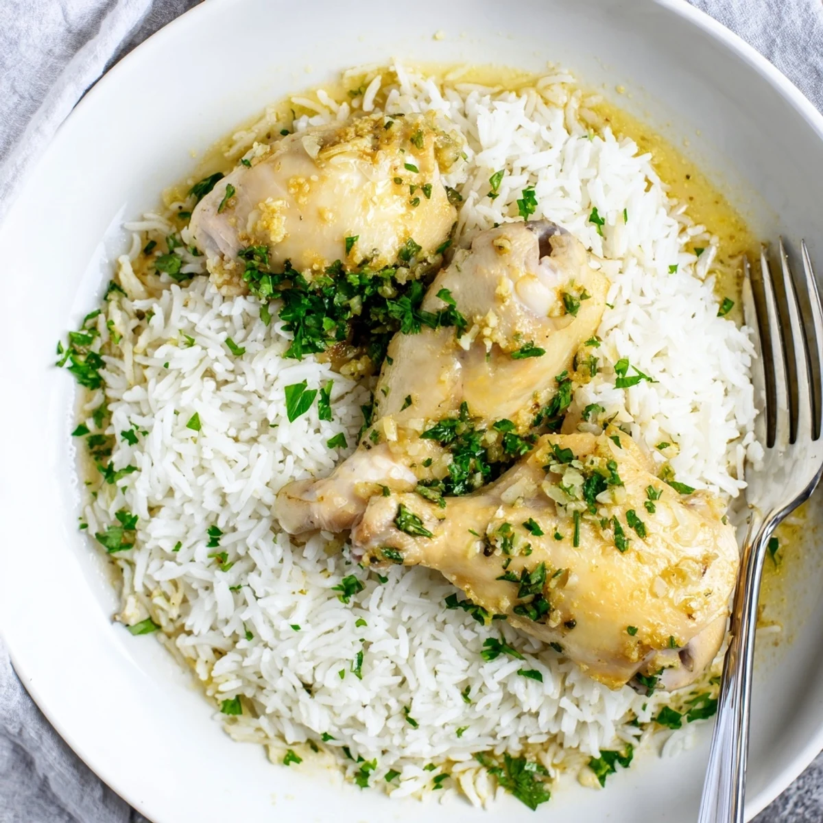 Juicy lemon herb chicken paired with fluffy white rice, drizzled with savory juices and garnished with parsley.