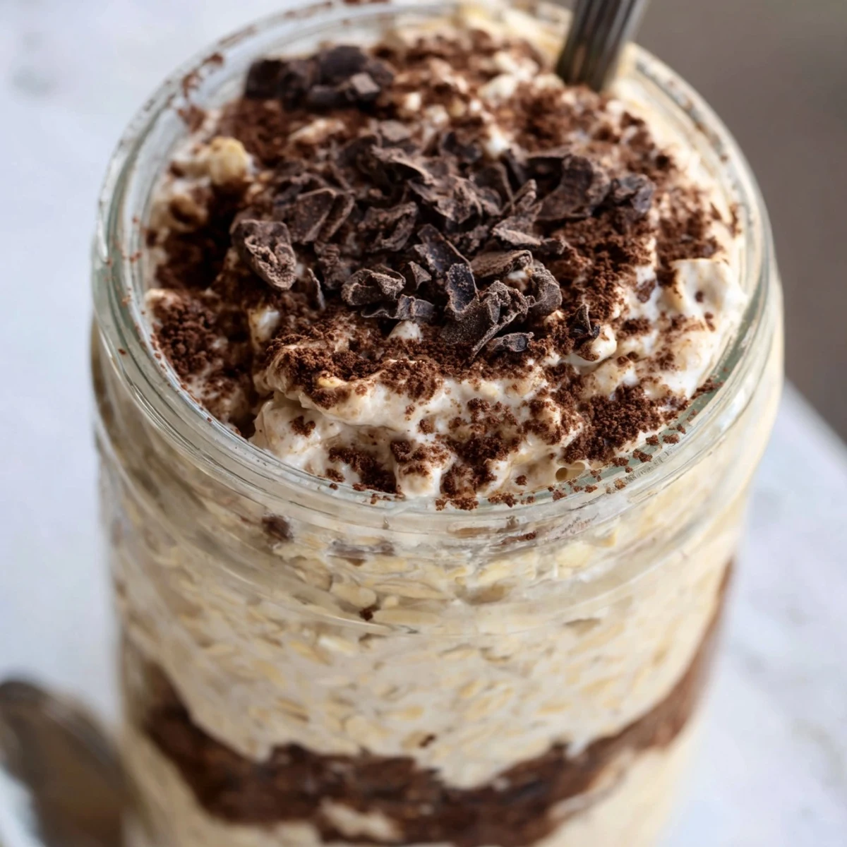 Creamy tiramisu overnight oats layered with rich espresso and dusted cocoa powder in glass jars