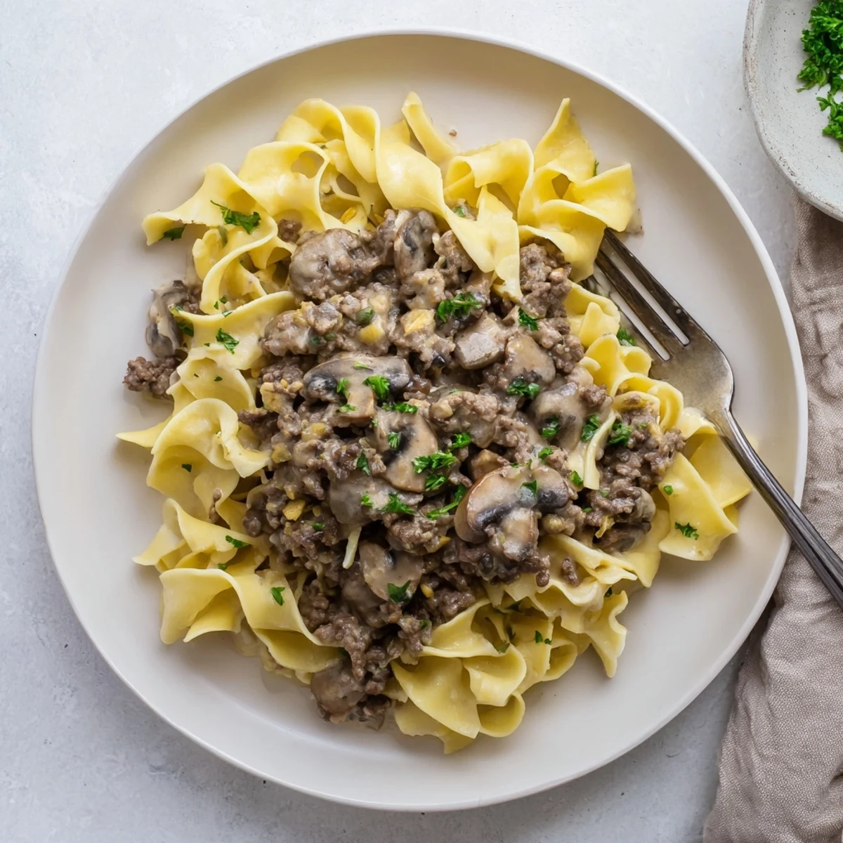 Hearty hamburger stroganoff in a rich sour cream sauce garnished with fresh parsley