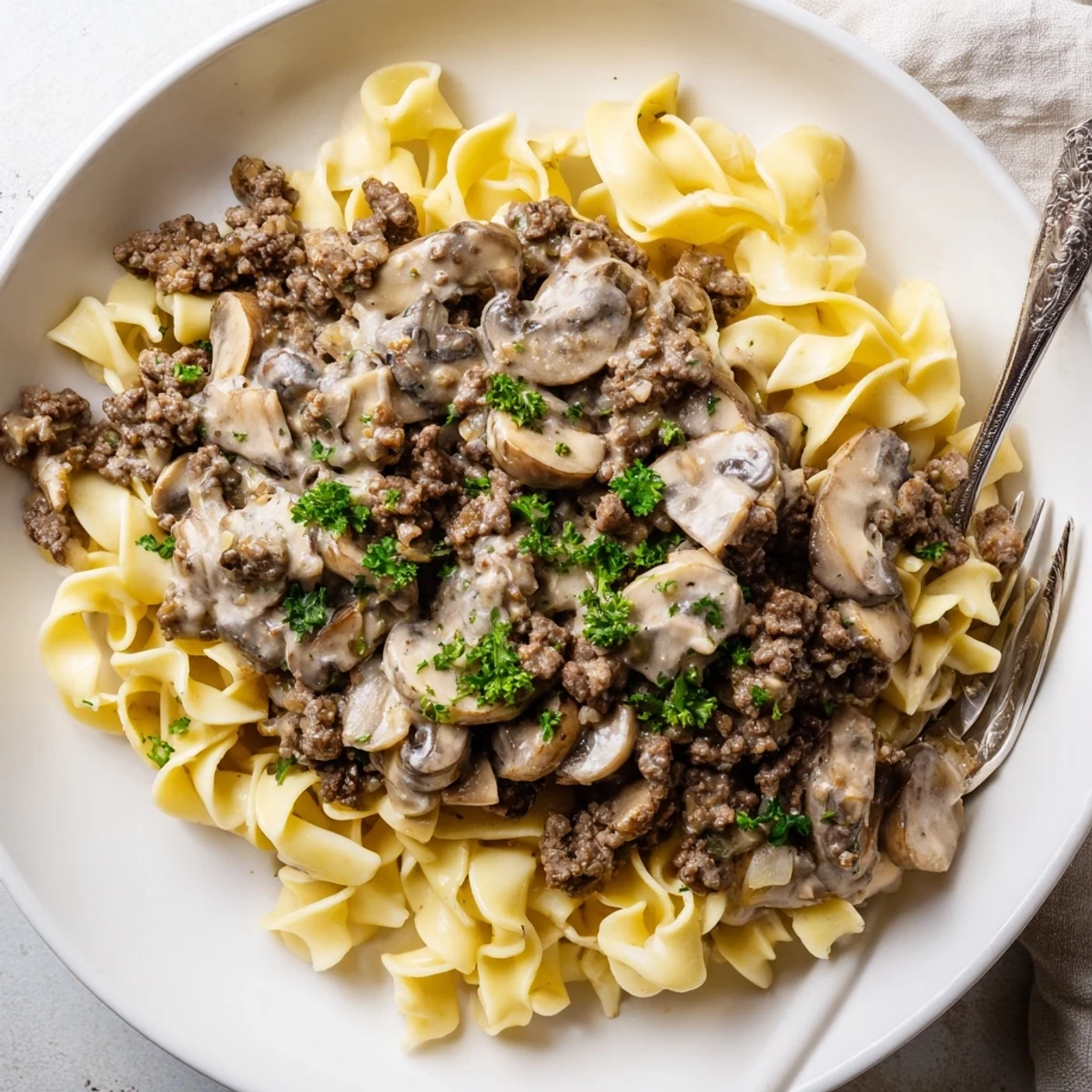 Golden egg noodles topped with savory hamburger stroganoff featuring beef and sautéed mushrooms