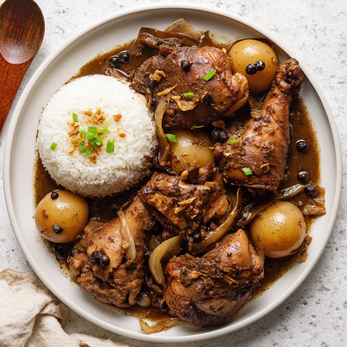Golden Filipino Chicken Adobo braised in rich soy vinegar sauce with steamed white rice