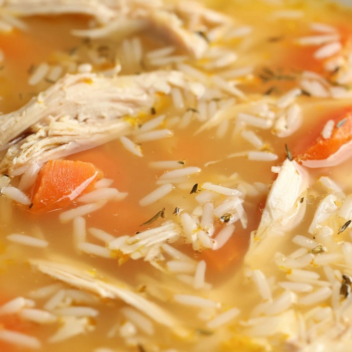 Steaming bowl of Crockpot Lemon Chicken Soup garnished with fresh parsley and lemon slices