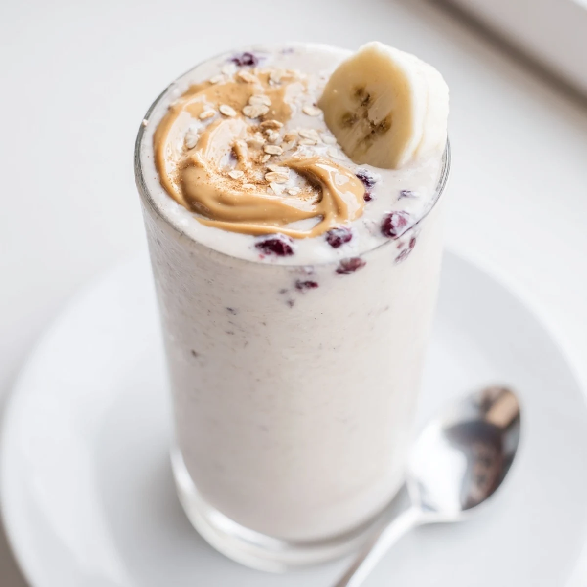 Berry-streaked High Protein Smoothie poured into two glasses, chilled and frothy.