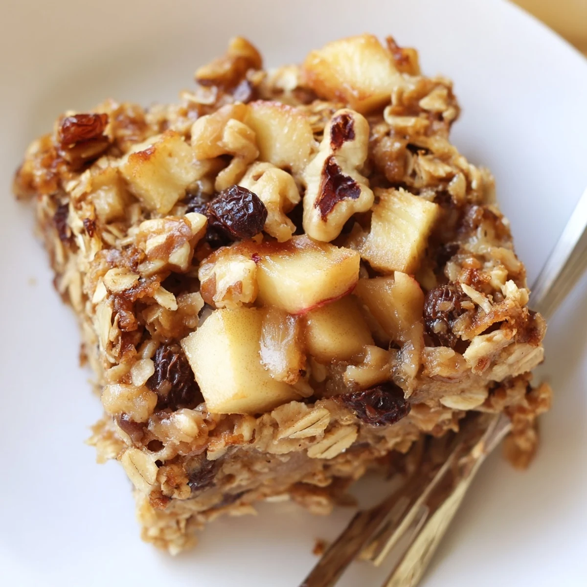 Warm Apple Cinnamon Oatmeal Bake topped with toasted nuts, golden crust visible