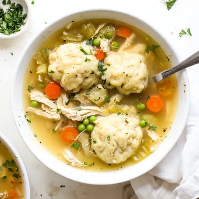 Serving hot One Pot Chicken Dumpling Soup, a comforting American main dish with chicken broth and veggies.