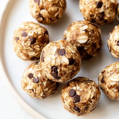 Five freshly made No Bake Peanut Butter Energy Bites arranged neatly, showing their chewy texture and sticky consistency, great for meal prepping or on-the-go snacks.  