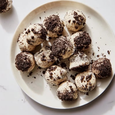 A close-up view of a Cream Cheese Oreo Protein Ball showing its creamy texture and Oreo coating, ideal for a quick snack.