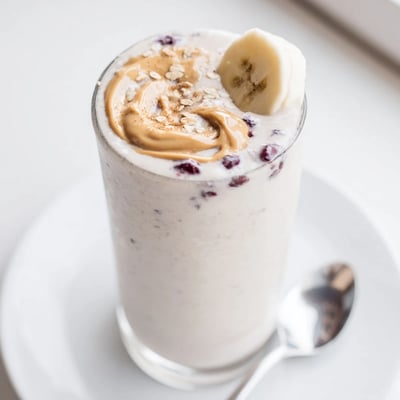 Berry-streaked High Protein Smoothie poured into two glasses, chilled and frothy.