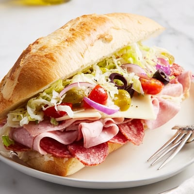 Toasted Italian Grinder Salad Sandwich layered with provolone, salami, and juicy tomatoes